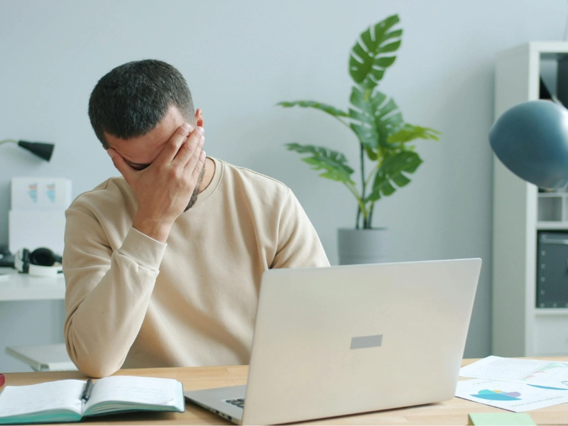 person stressed about unexpected bills showing why you need an emergency fund